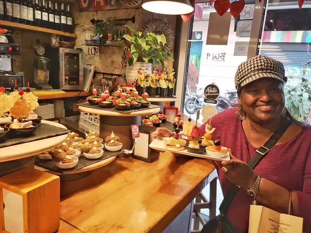 Woman enjoying a vibrant selection of traditional tapas in a cozy Barcelona tavern during a private food and drink tour.