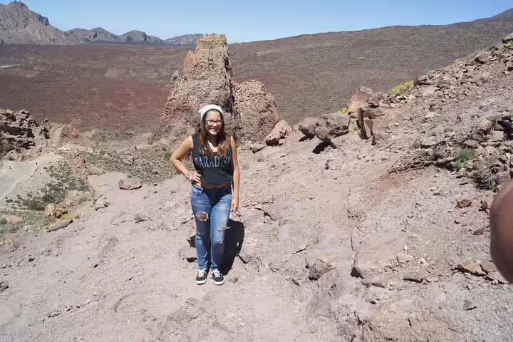 Woman exploring rugged volcanic landscape on a private cruise excursion, perfect for adventurous travelers.