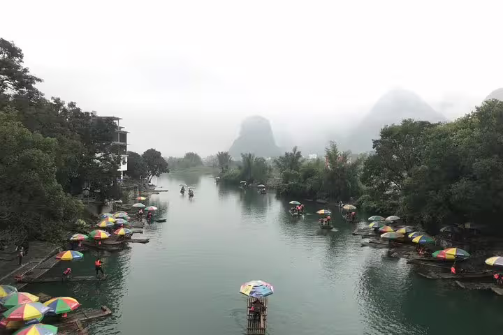 Colorful bamboo rafts on a serene river in Yangshuo, ideal for a relaxing Xingping boat tour experience.