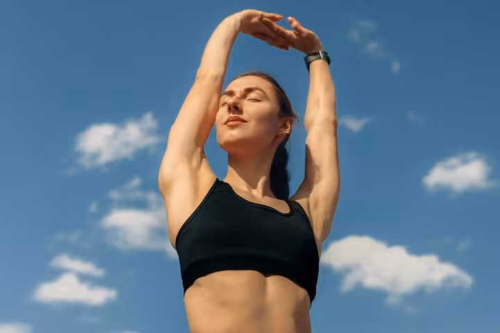 Close-up of yogi stretching under blue Santorini sky, calming caldera yoga session and mindfulness