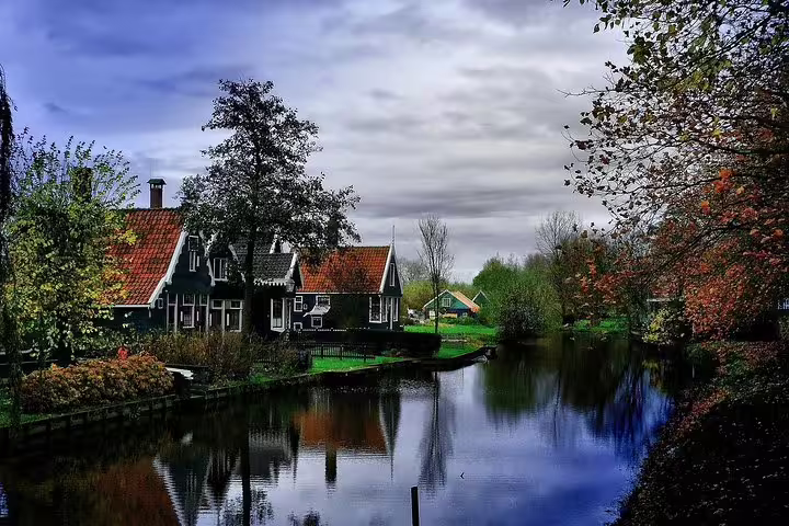 Zaanse Schans canal with traditional Dutch houses and red roofs, scenic stop on private day trip from Amsterdam