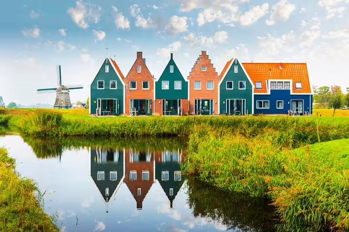 Colorful Zaanse Schans houses with windmill reflected in canal, private day tour from Amsterdam to Marken