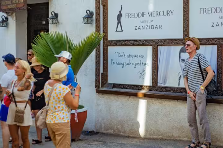 Visitors exploring the Freddie Mercury Museum in Zanzibar's Stone Town, a must-see stop on a walking tour.