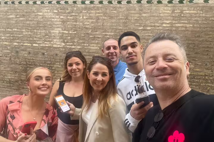 Friends take a selfie using a mobile app during a Zaragoza scavenger hunt self-guided city tour