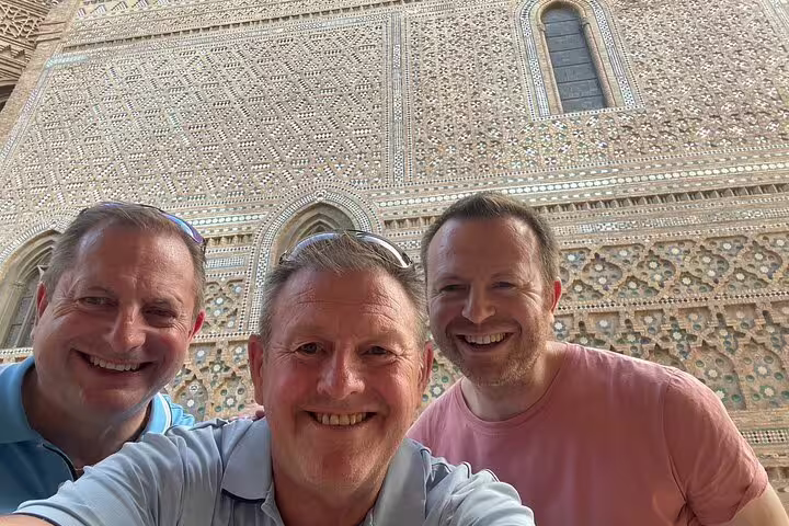 Smiling travelers selfie by Zaragoza’s ornate Mudejar wall on a self-guided scavenger hunt tour