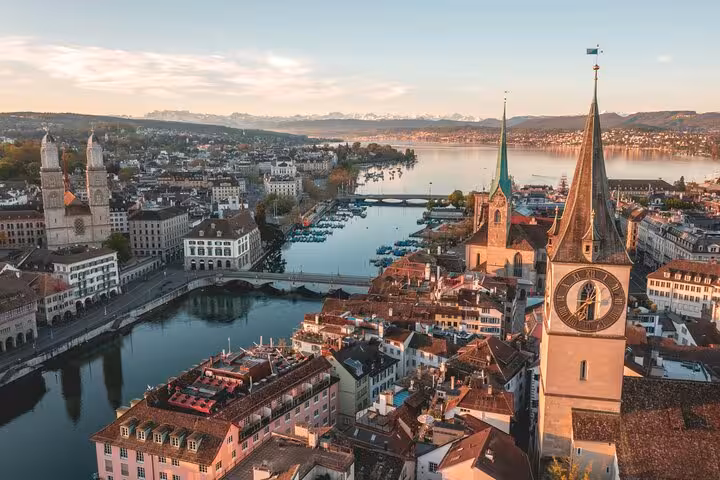 Aerial view of Zurich's cityscape with prominent churches and Lake Zurich, perfect for tour exploration.