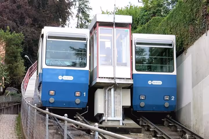 Blue funicular railway cars ascending a steep track, a highlight of the Zurich transportation adventure tour.