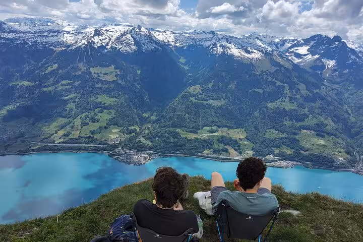 Hikers resting on Leistkamm Ridge with sweeping Walensee and snow-capped Swiss Alps on Zurich day trip