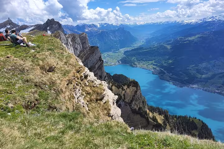 Hikers resting on Leistkamm Ridge cliff with turquoise Walensee views on Zurich guided hiking day trip
