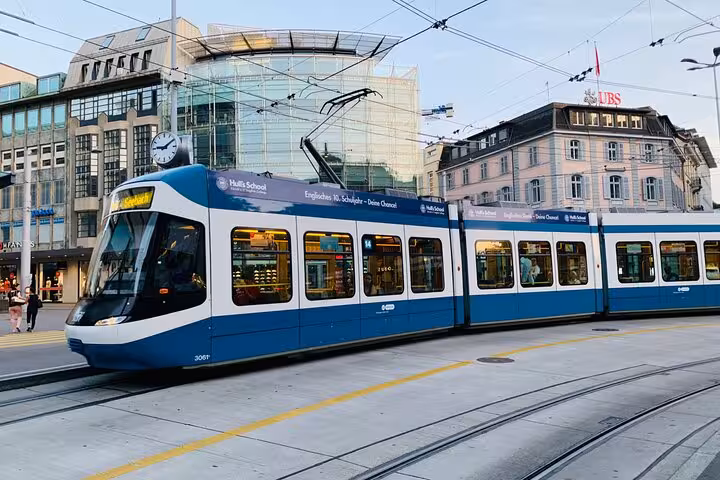 Modern tram on Zurich street with iconic buildings, highlighting Swiss urban transport experience.