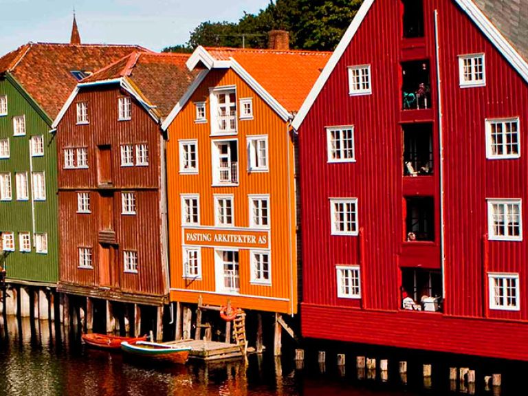 Attractions-in-Bryggen: Bryggen is a historic area in Bergen, Norway that is known for its colorful row of wooden buildings that line the harbor. The area has a rich history and is considered a UNESCO World Heritage Site.