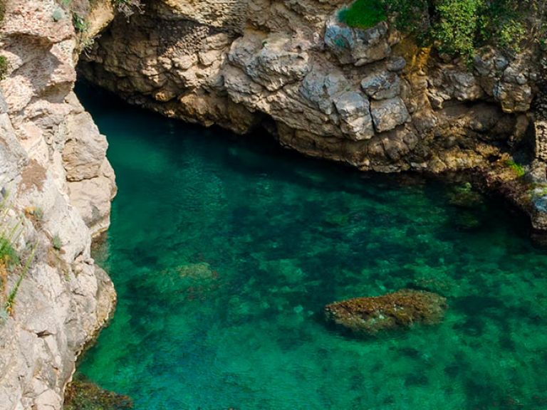 Immerse yourself in the Baths of Regina Giovanna, southern Italy's hidden treasure. Near Massa Lubrense village, this secluded cove brims with natural pools, dramatic cliffs, and crystalline waters. Named after Queen Joanna II of Naples, it once served as her 15th-century retreat.