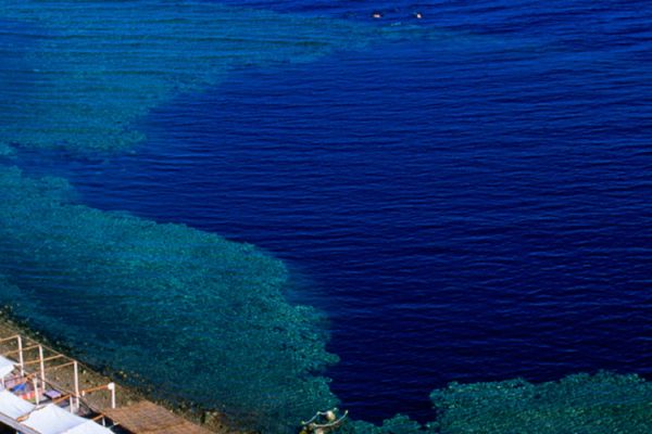 The Blue Hole in Dahab, Egypt is a famed diving site on the Red Sea coast. This underwater sinkhole, reaching 130 meters, attracts global divers and boasts vibrant coral reefs and marine life.