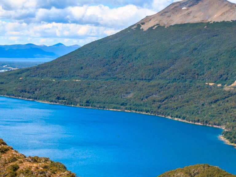 Lake Fagnano, nestled amidst mountains and a wild plateau, captivates with its vibrant blue hues and choppy waters. Surrounded by snow-capped peaks, it's a prominent feature of Tierra del Fuego National Park, the largest in the region.