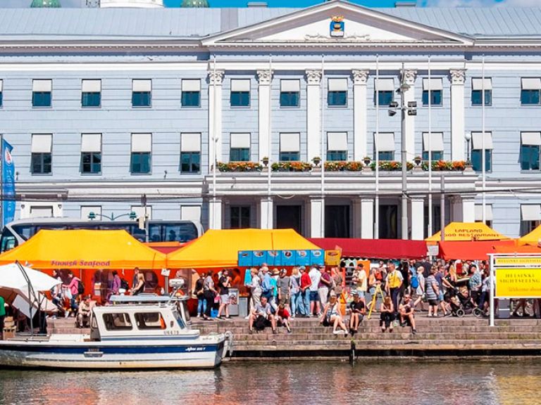 Helsinki Market Square, or 'Helsingin Kauppatori', sits at Helsinki's heart in Finland. A buzzing tourist magnet, this open-air market is filled with vibrant street performers, diverse stalls offering local specialties, handicrafts, and souvenirs.