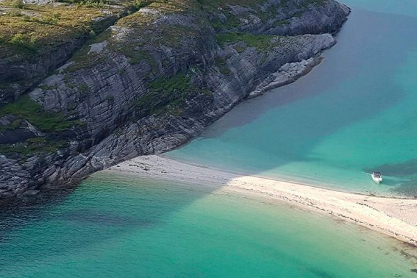 Hovdsundet Beach, a secluded Instagram-famous spot in Northern Norway, boasts white sand, turquoise water, and stunning cliffs. Its unique Scandinavian tranquility makes it a beloved escape from more touristy areas.