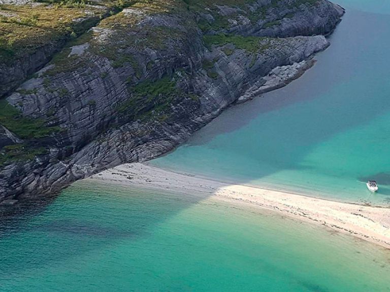 Hovdsundet Beach, a secluded Instagram-famous spot in Northern Norway, boasts white sand, turquoise water, and stunning cliffs. Its unique Scandinavian tranquility makes it a beloved escape from more touristy areas.