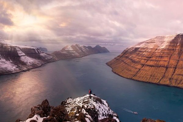 Hvíthamar viewpoint, situated above Funningur on Eysturoy Island, offers panoramic views of the village, rugged coastline, and majestic mountains rising from the sea, making it a must-visit scenic spot in the Faroe Islands.