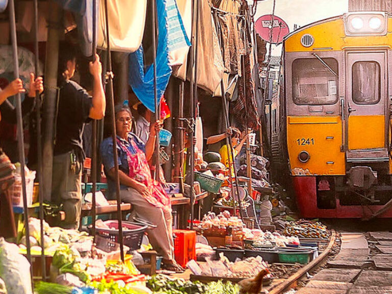 The famous Maeklong Railway Market in Samut Songkhram Province offers a unique experience as trains regularly pass through. Vendors and customers quickly clear the way, resuming their activities once the train has passed. It's a must-see attraction for visitors.
