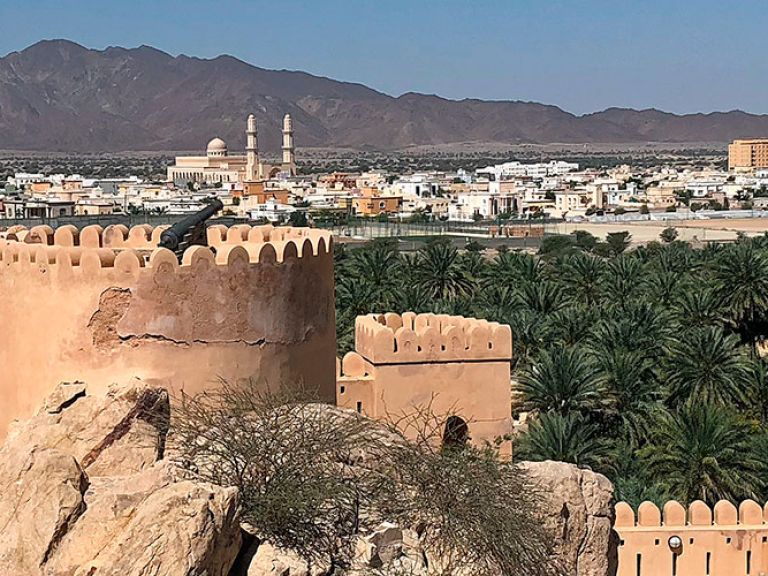 Nakhl Fort in Oman, dating to the 17th century, is a renowned tourist spot. Perched on rocks, it offers breathtaking views of palm groves and mountains.