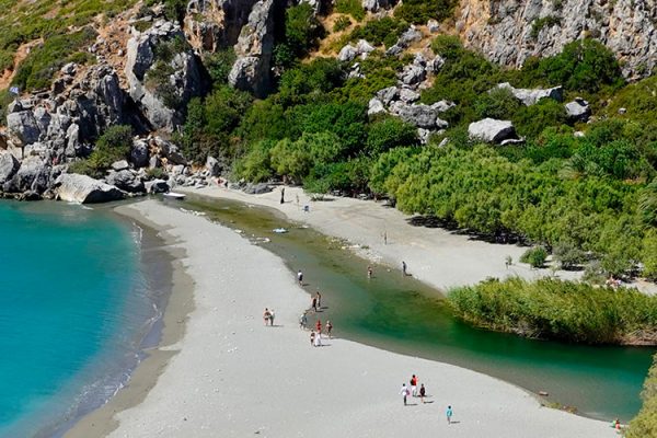 Preveli Beach, a secluded gem on Crete's south coast, lies at the mouth of Kourtaliotiko Gorge. With tall palm trees, rugged cliffs, fine golden sand, and crystal clear waters, it's a perfect spot for swimming and sunbathing.