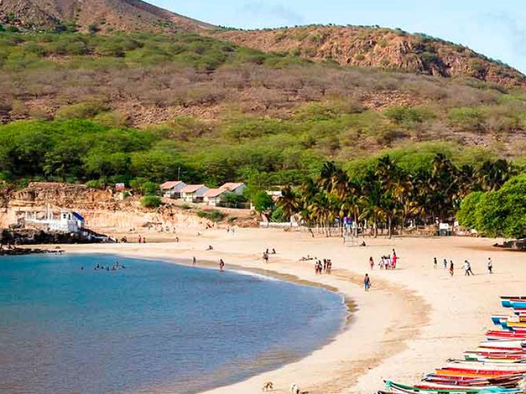 Tarrafal Beach on Santiago Island, Cape Verde, is a stunning escape with its crescent shape, turquoise waters, white sand, and rugged landscape, making it a popular destination for relaxation and beauty.