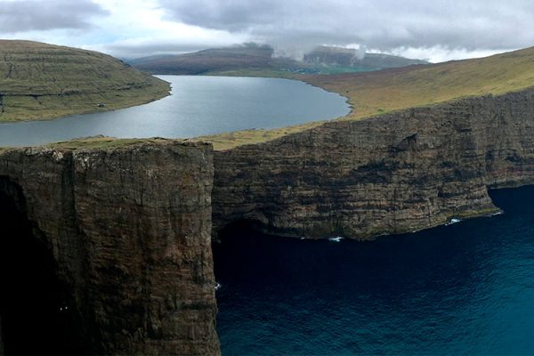 Trælanípan, or "Slave Cliff," on Vágar Island, Faroe Islands, attracts tourists with its dramatic landscapes and Atlantic views, its name harking back to Viking Age punishments.