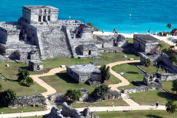 Tulum, an important Maya trading hub in Quintana Roo, Mexico, is the only archaeological site facing the Caribbean Sea. It features fortified temples, palaces, a unique observatory, and the renowned "El Castillo".