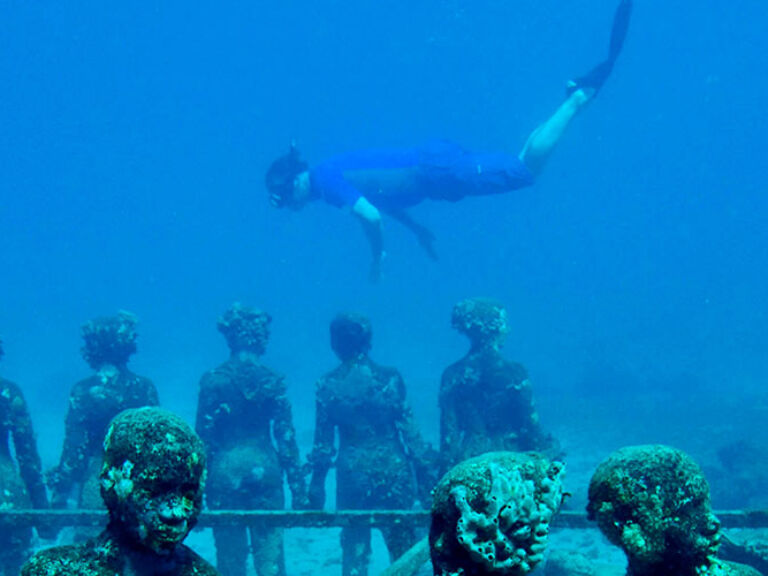 Cancun's Underwater Museum, a top attraction, showcases 500+ locally crafted, life-size statues across two galleries. Depicting Mexican history and culture, visitors can explore these underwater scenes through snorkeling or scuba diving, often amidst diverse marine life.