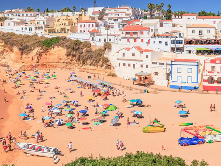 Carvoeiro, in Algarve, Portugal, features a beach, fishing harbor, cafes, and restaurants. Nearby is the famed Benagil beach with its renowned sea cave accessible by boat.