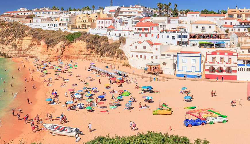 Carvoeiro, in Algarve, Portugal, features a beach, fishing harbor, cafes, and restaurants. Nearby is the famed Benagil beach with its renowned sea cave accessible by boat.