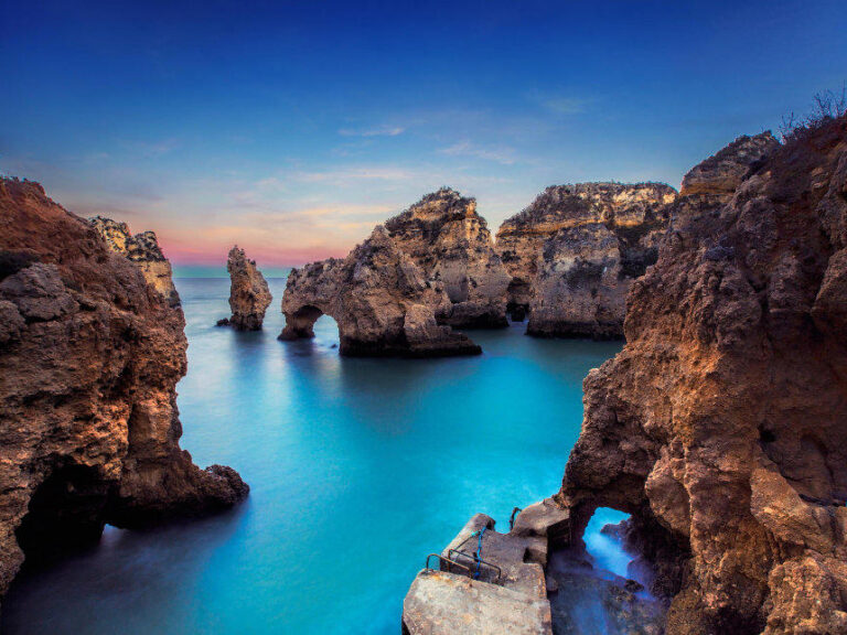 Experience the breathtaking beauty of Ponta da Piedade on Portugal's Algarve coast. Marvel at the towering cliffs, turquoise waters, and captivating rock formations. Explore on foot or by boat, discovering hidden caves and arches. Feel the gentle sea breeze and listen to the soothing waves. Descend to the water's edge for a refreshing swim or kayak adventure. Capture unforgettable photos of this coastal paradise.