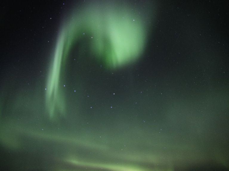 The Northern Lights, also known as the aurora borealis, is a natural light display in the Earth's sky, predominantly seen in the high-latitude regions (around the Arctic and Antarctic). These lights are caused by the collision of solar particles with atoms in the Earth's atmosphere, which results in the emission of light in different colors, primarily green, yellow, pink, purple, and red. The intensity and color of the lights can vary depending on the level of solar activity, and they are most visible during the dark winter months.