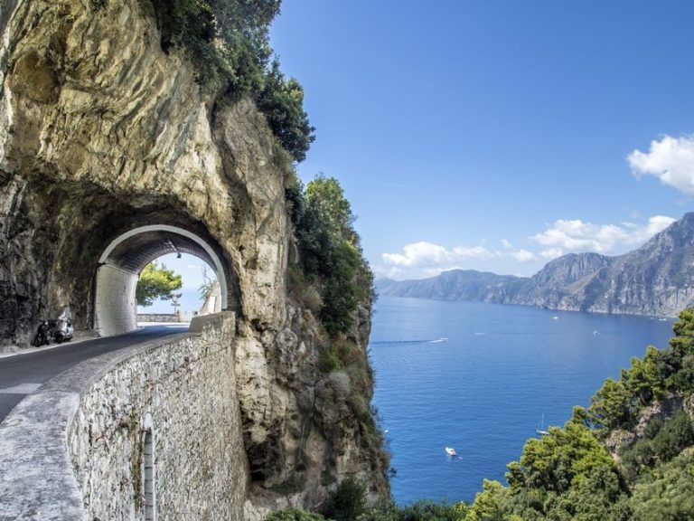 Positano & Amalfi - The tortuous street slips over deep gorges and runs down toward the beach and climbs up again along a...