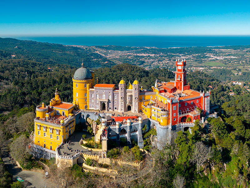 Lisbon Travel Guide: Sintra, just a short train ride away, is a must-visit for any Lisbon itinerary. With its romantic palaces, such as the Pena Palace and Quinta da Regaleira, and stunning gardens, Sintra feels like stepping into a fairytale. This UNESCO World Heritage site offers a day of exploration and a chance to glimpse Portugal's royal past.
